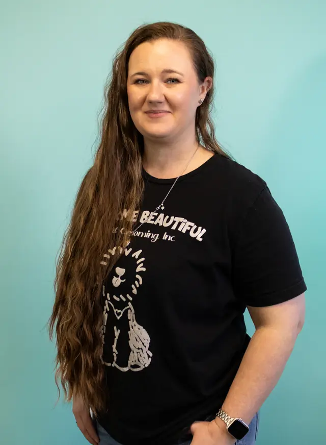 A team member with long hair in a black Bark Me Beautiful tee